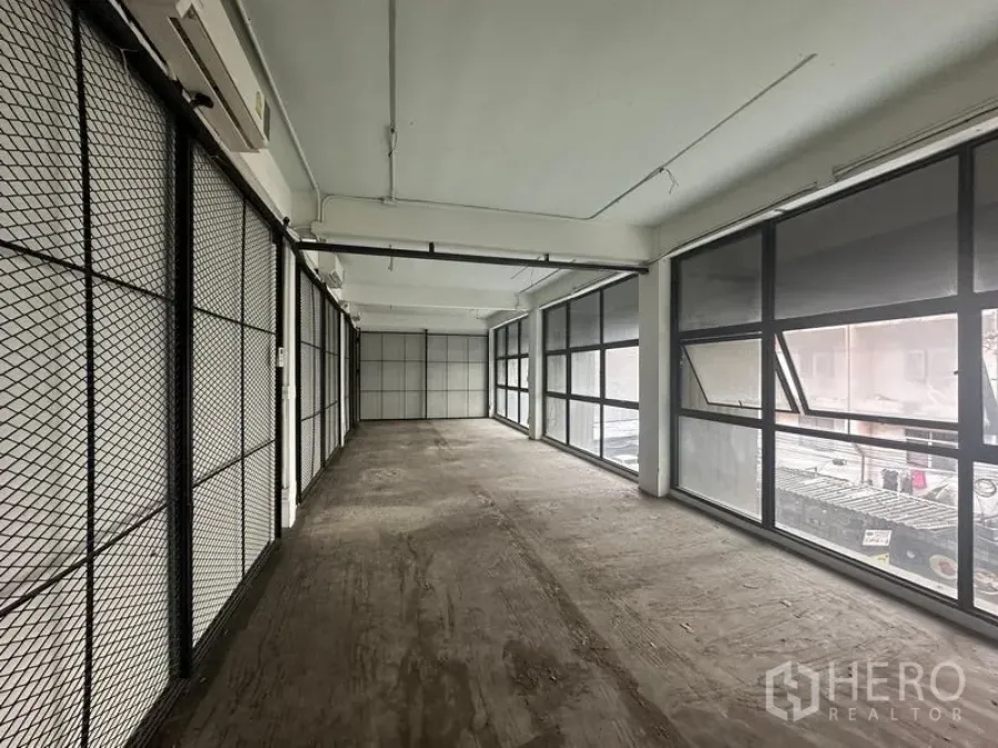 Retail Space for rent - Empty 48 sqm retail space in Watthana with floor-to-ceiling windows and metal mesh partitions near BTS Phra Khanong.