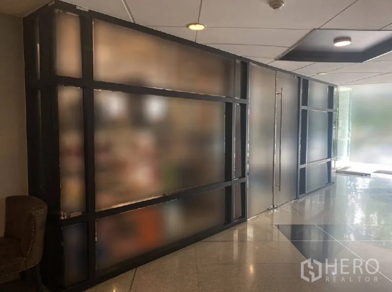 Retail Space for rent in Watthana, Bangkok - Ground-floor retail unit with frosted glass storefront, polished lobby flooring, and recessed ceiling lights.