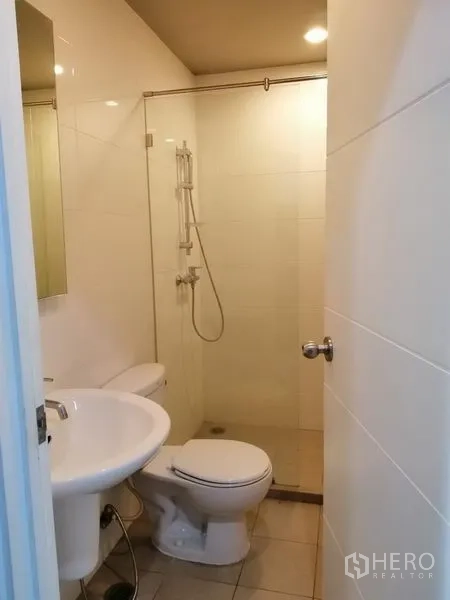 Condominium for rent in Watthana, Bangkok - Modern bathroom with glass shower enclosure, toilet and basin