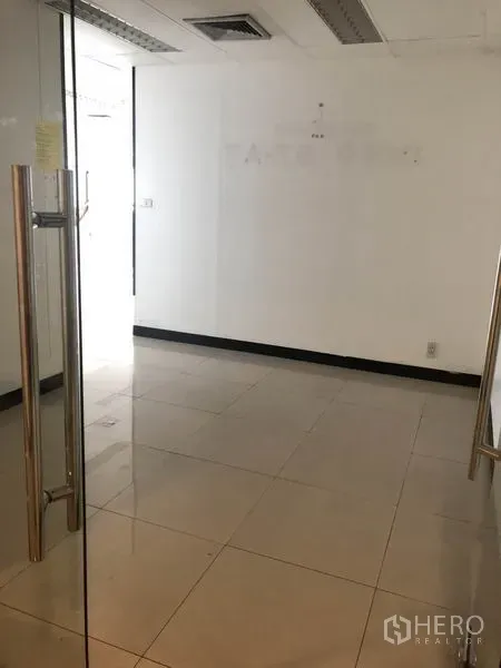 Office Space for rent in Watthana, Bangkok - View from doorway into a small reception area with white walls and glass door.
