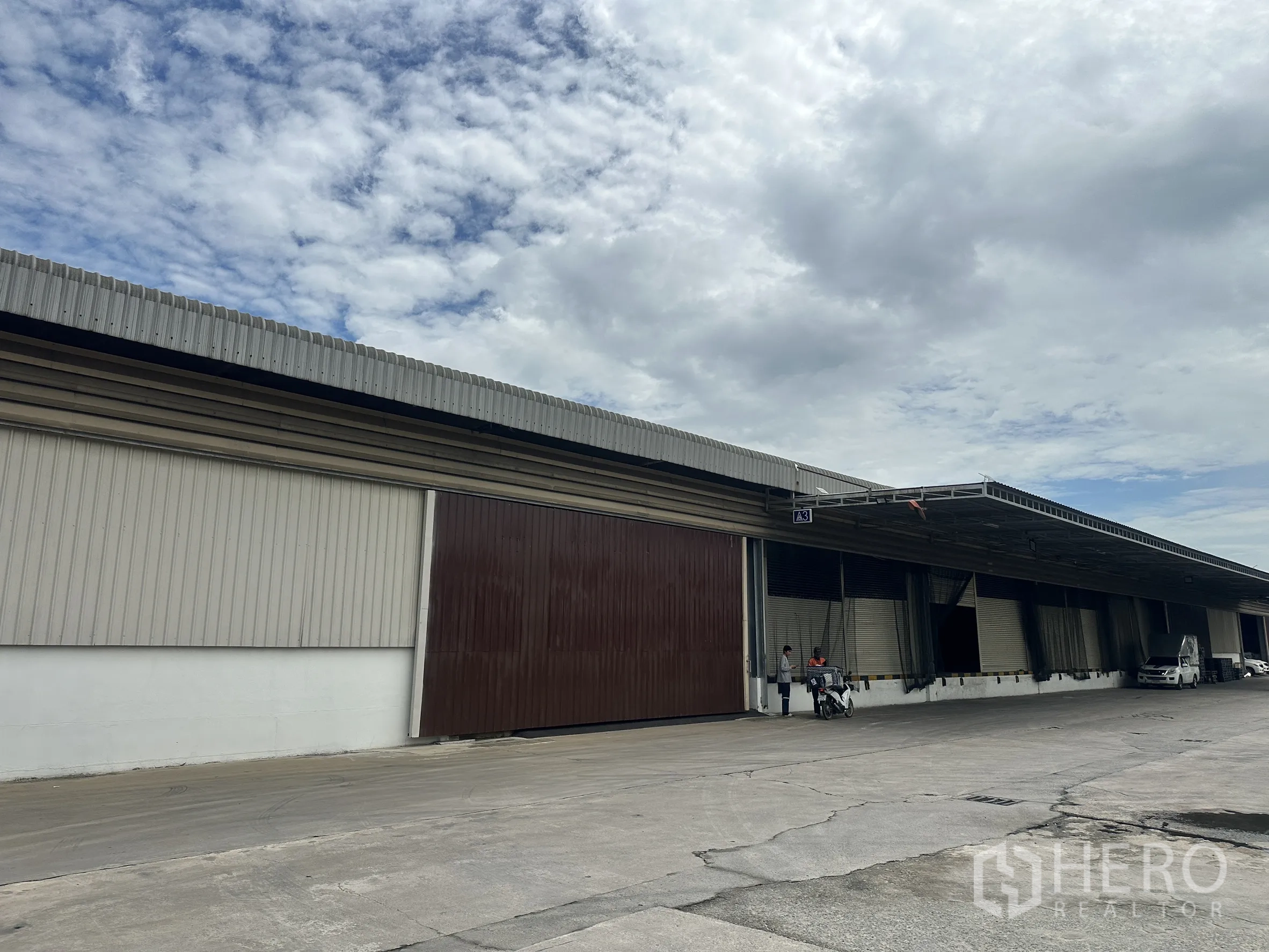 Factory for rent in Lat Krabang, Bangkok - Extended warehouse frontage with several roller shutters and truck access lane.