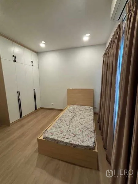 Detached House for rent in Mueang Nonthaburi, Nonthaburi - Bedroom with single bed, built-in wardrobes and full-length curtains.