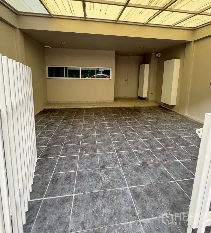 Townhouse for rent in Suan Luang, Bangkok - Covered tiled carport for two cars with sliding gate.