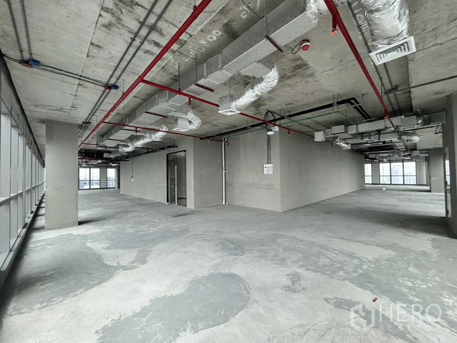 办公空间 出租在Huai Khwang, Bangkok - 开放式毛坯办公室，裸顶、混凝土地面与面向城市的窗户。