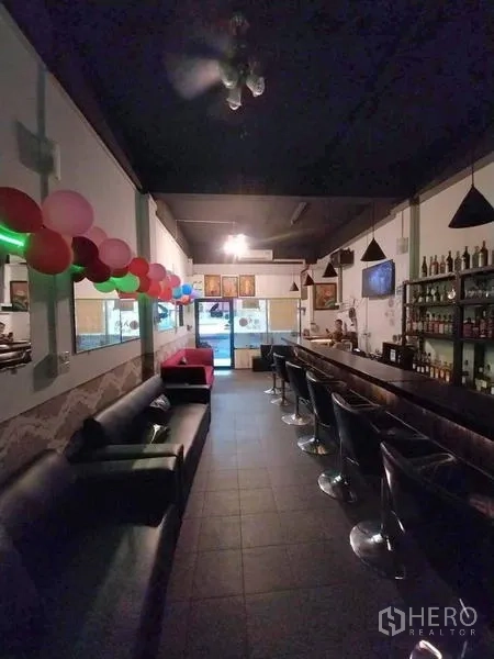 Shophouse for rent in Khlong Toei, Bangkok - Bar lounge with sofas, bottle shelves and balloon decorations near the shopfront.
