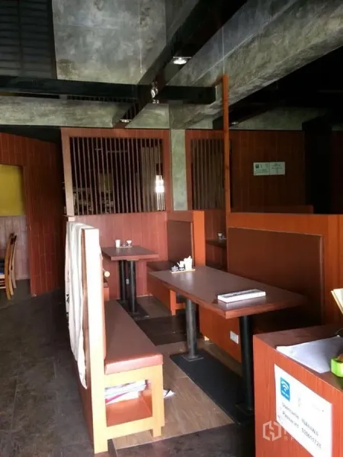 Retail Space for rent in Khlong Toei, Bangkok - Built-in booth seating with wooden partitions and a concrete ceiling inside the retail unit.
