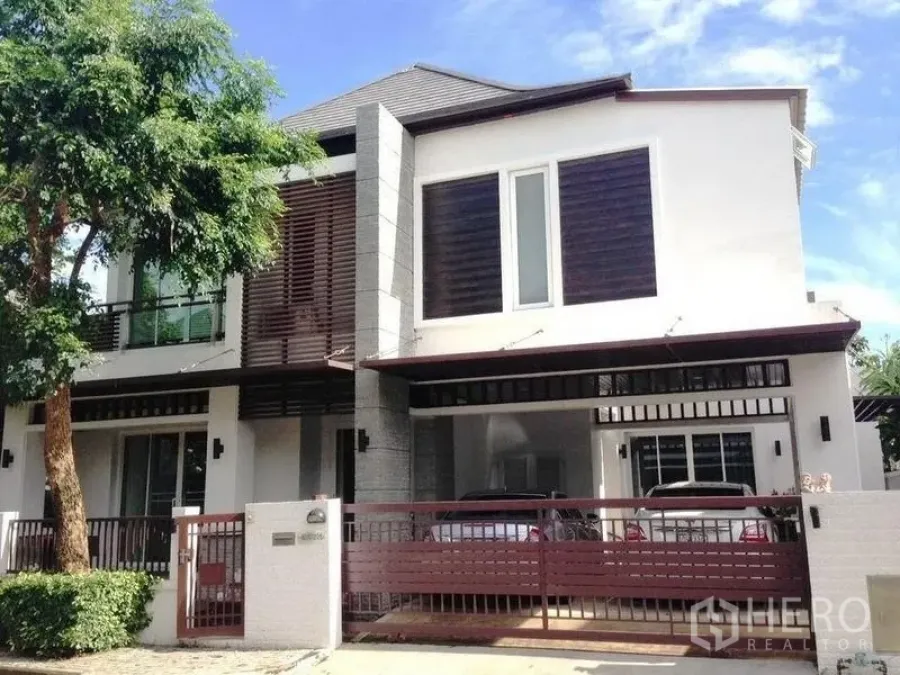 Detached House for rent or sale in Prawet, Bangkok - Front facade with gated driveway and covered carport for two cars.