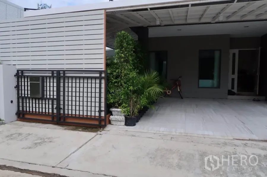 Detached House for rent in Prawet, Bangkok - Modern gated entrance with covered carport and greenery at a detached house in Prawet, Bangkok
