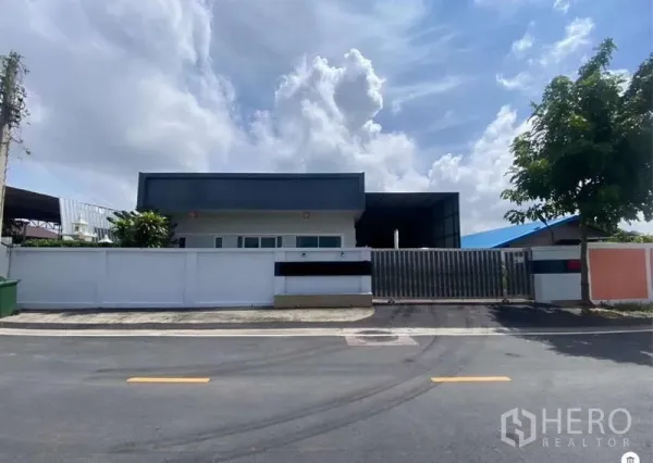 Warehouse for sale in Mueang Samut Prakan, Samut Prakan - Gated warehouse with front office and high fence on a wide clean road in Mueang Samut Prakan.