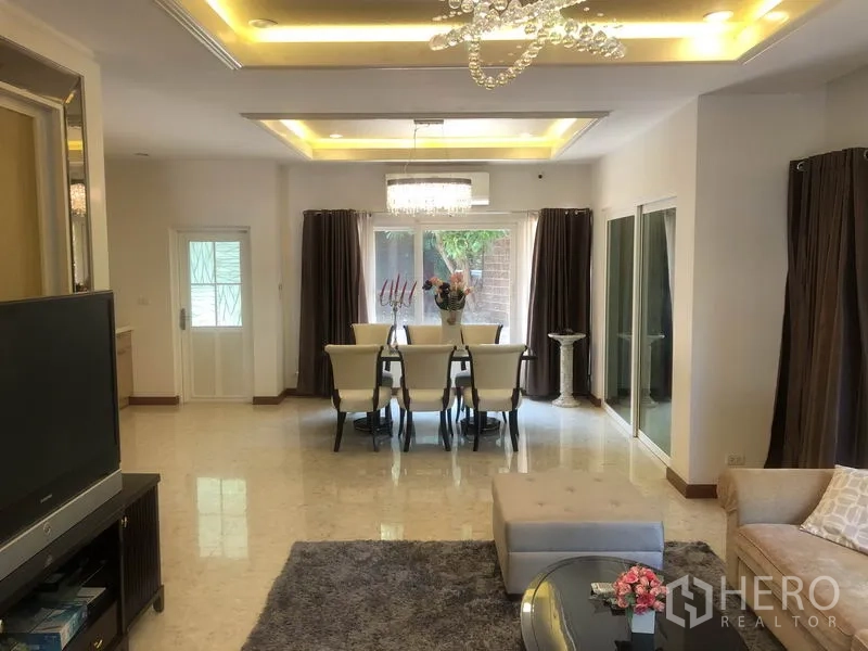 Detached House for rent or sale in Pak Kret, Nonthaburi - Open-plan living and dining area with chandelier, large windows and glossy floors.