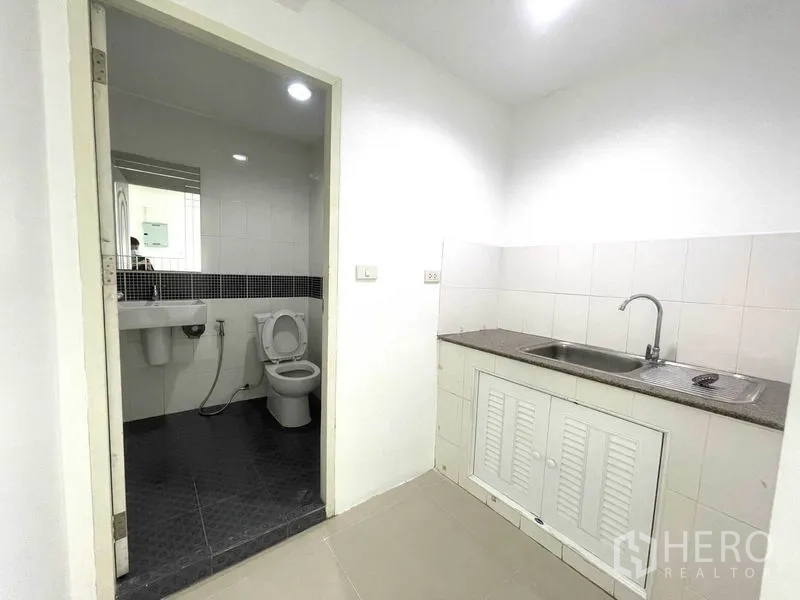 Office Space for rent in Khlong Toei, Bangkok - Pantry with sink beside the tiled bathroom inside the office.