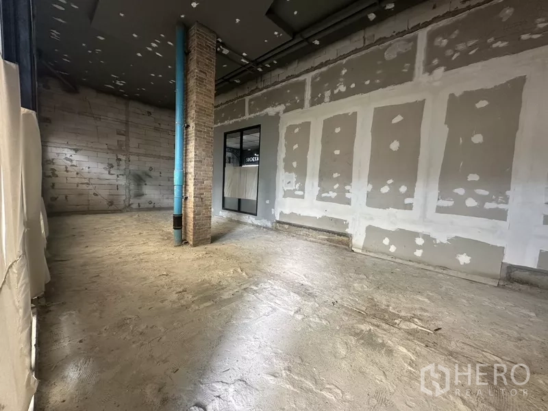 Retail Space for rent in Khlong Toei, Bangkok - Open-plan shell space showing drywall, concrete floor and a brick column for flexible layout.