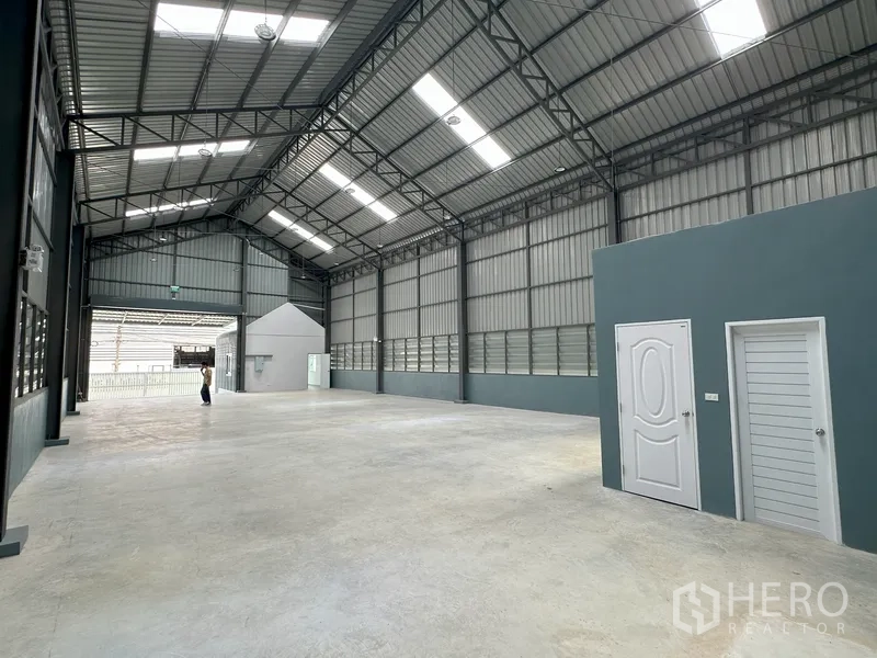 工厂 出租在Khlong Luang, Pathum Thani - 室内通道带天窗，侧墙排列白色服务门。