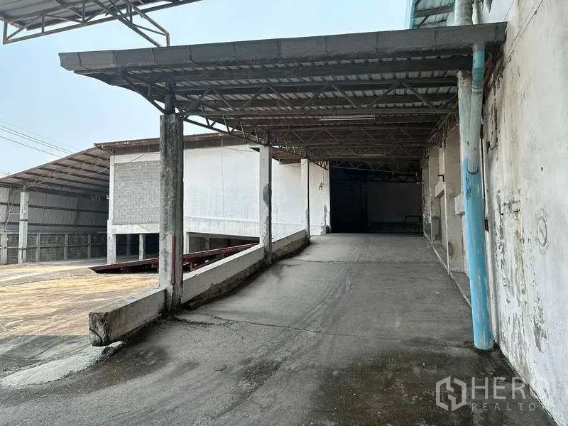 Factory for rent or sale in Bang Phli, Samut Prakan - Covered loading ramp leading up to a warehouse entrance for truck access.