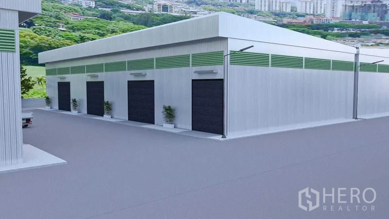 Warehouse for rent in Bang Phli, Samut Prakan - Side view of the warehouse showing several loading bay doors and generous truck circulation space.