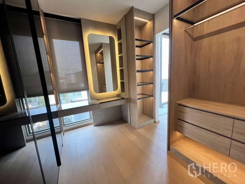Townhouse for rent in Phra Khanong, Bangkok - Lighted dressing room with built-in wardrobes and a makeup vanity.
