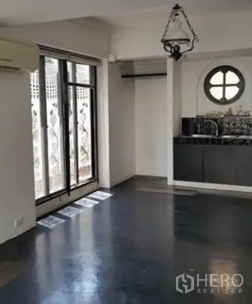 Home Office for sale in Wang Thonglang, Bangkok - Ground-floor open space with compact pantry, round feature window and sliding glass doors to a small patio.