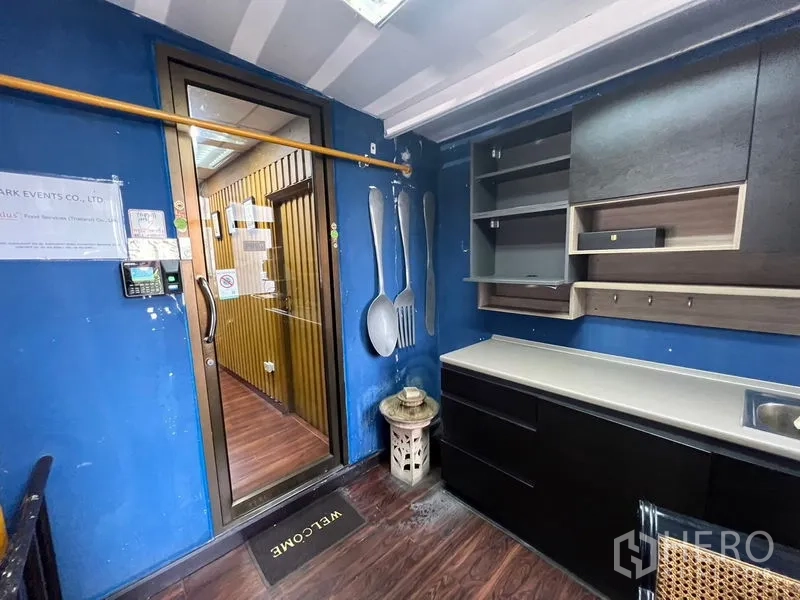Retail Space for rent or sale in Khlong Toei, Bangkok - Compact pantry or service room with cabinetry and sink beside a glass door.