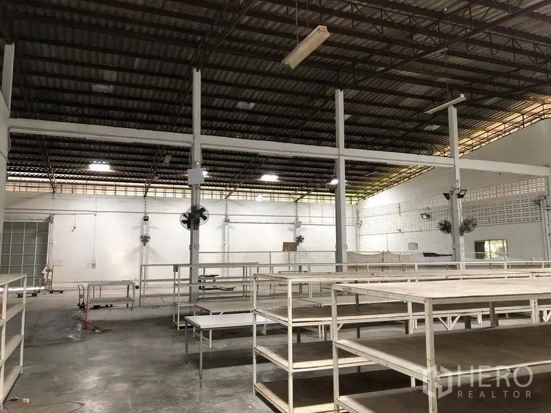 Warehouse for rent in Bang Kapi, Bangkok - Interior view of warehouse racks, concrete floor and ventilation fans.