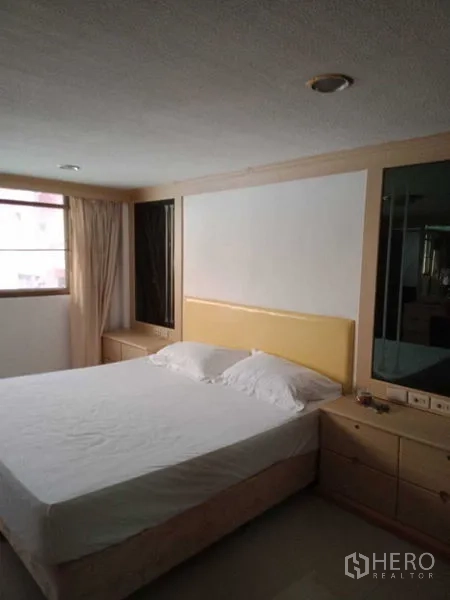 Townhouse for rent in Khlong Toei, Bangkok - Bright bedroom with double bed and large window with curtains.