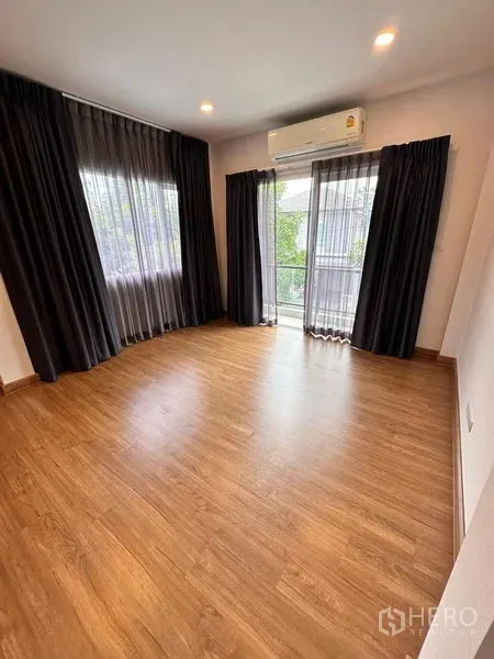 Detached House for sale in Prawet, Bangkok - Bright master bedroom with balcony access, wood floor and split A/C.
