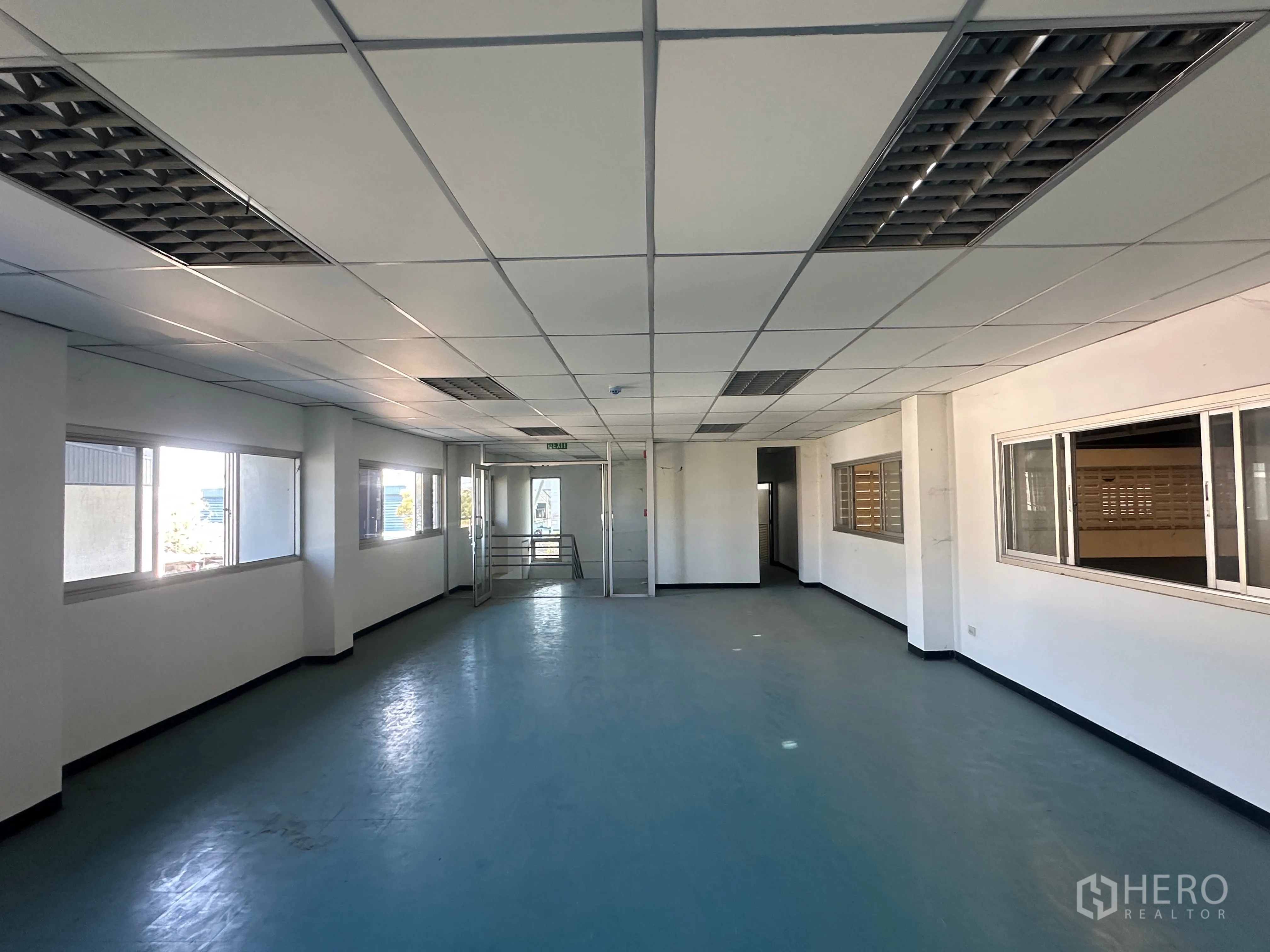 Factory for rent in Bang Pa-in, Phra Nakhon Si Ayutthaya - Upstairs office corridor with windows, fluorescent fixtures, and vinyl flooring.