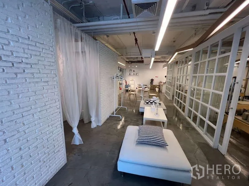Retail Space for rent - Open-plan retail floor featuring glass partitions, industrial ceiling lighting, and lounge seating.