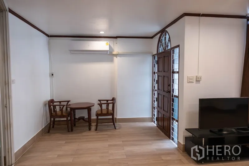 带办公室的家 出租在Khlong Toei, Bangkok - 入口休闲角，小圆桌、电视柜和拱形木门。