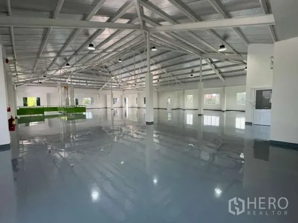 Warehouse for rent in Mueang Samut Prakan, Samut Prakan - Wide warehouse hall featuring a steel truss roof, epoxy floor and multiple windows.