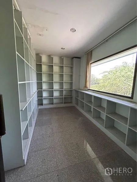 Warehouse for rent in Sam Phran, Nakhon Pathom - Storage room with floor-to-ceiling built-in shelves and a large window.