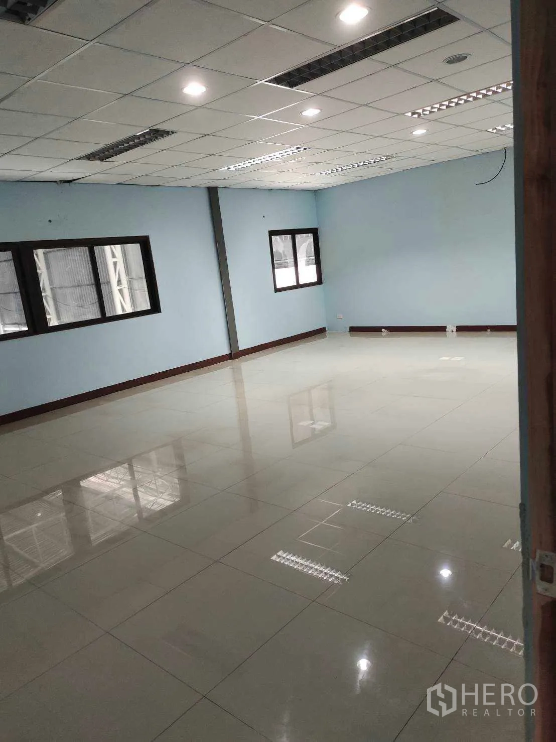 Factory for sale in Nikhom Phatthana, Rayong - Large open office space with multiple windows, drop ceiling and glossy tiles.