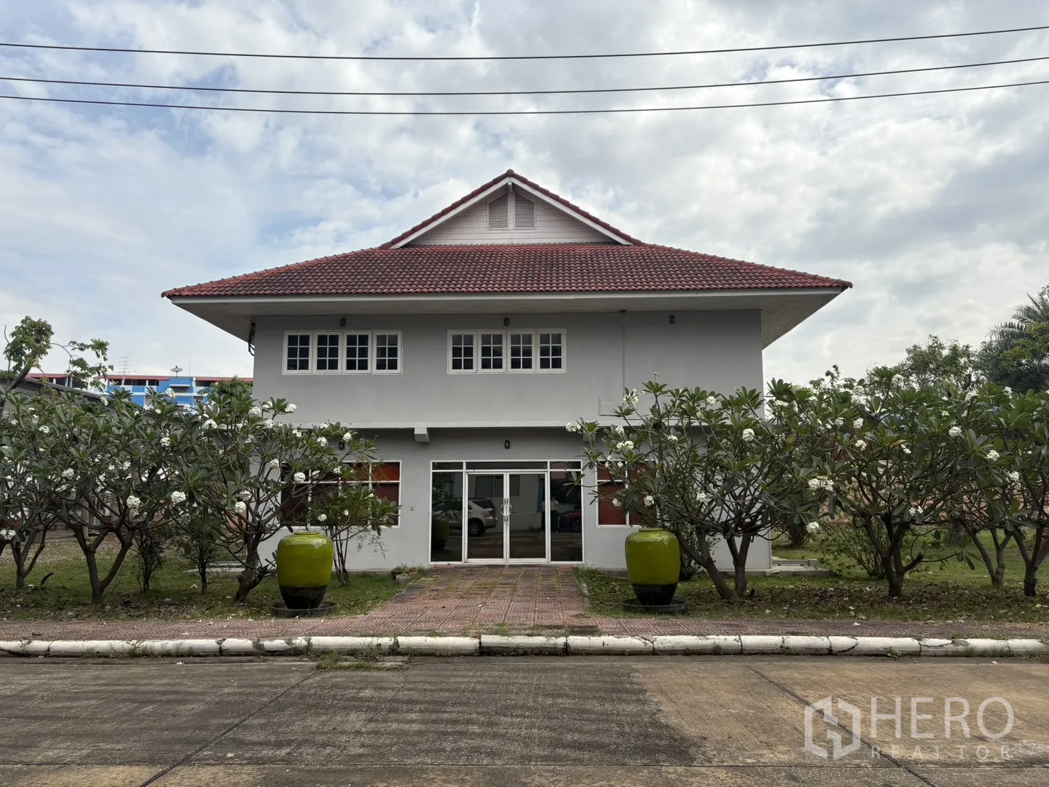 Factory for rent in Phra Pradaeng, Samut Prakan - Two‑storey secondary office building with red tile roof and landscaping.