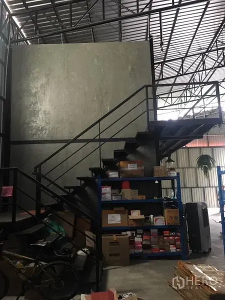 货栈 出租在Bang Kapi, Bangkok - 通往夹层办公室的钢楼梯，货架存储与高屋顶。