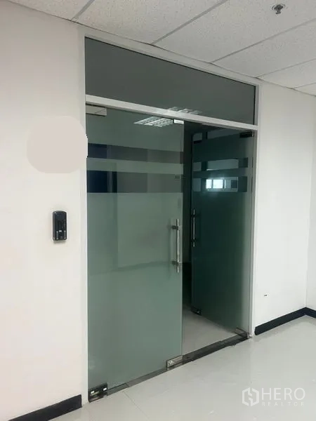 Office Space for rent - Frosted glass double doors with metal handles and access control at the office entrance.
