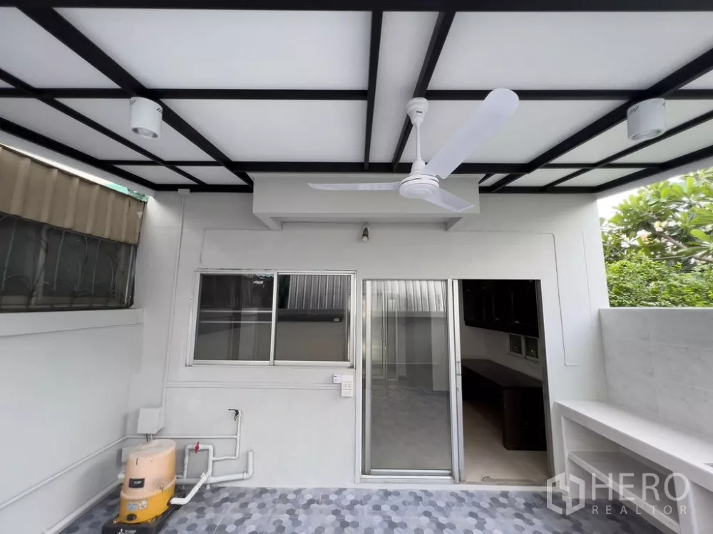 Home Office for rent in Lat Phrao, Bangkok - Covered rear terrace with ceiling fan and sliding doors to the interior.