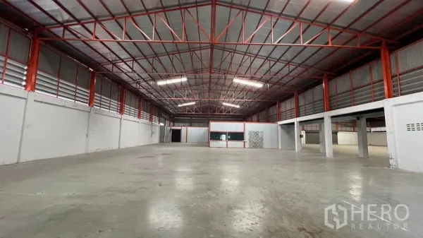 Warehouse for rent in Thanyaburi, Pathum Thani - Spacious warehouse hall with high red steel truss roof and smooth concrete floor.