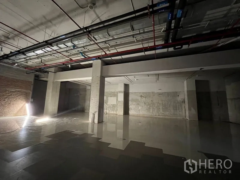 Retail Space for rent - Large shell retail space with concrete columns, exposed ceiling services and tiled flooring.