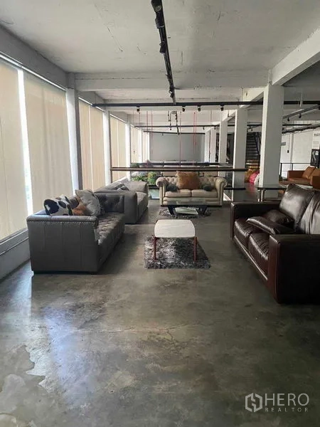 Retail Space for rent in Bang Na, Bangkok - Bright showroom zone with sofas along large windows and concrete flooring.