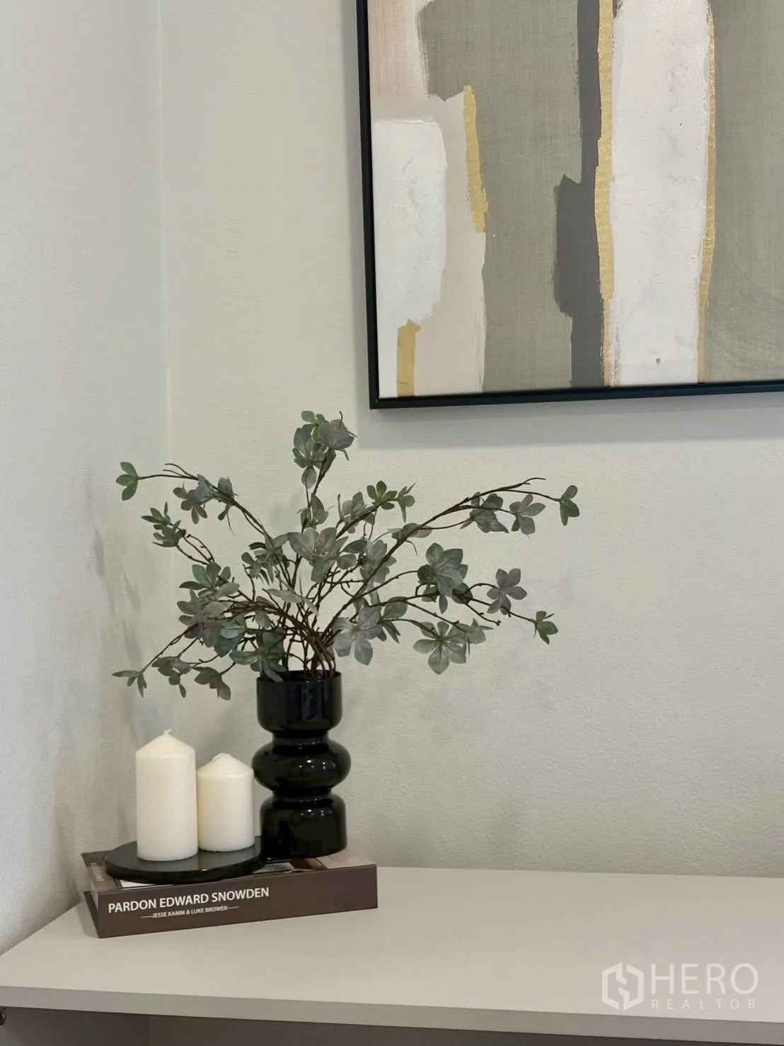 Townhouse for rent in Huai Khwang, Bangkok - Minimalist decor of vase and candles on a side table beneath abstract art.