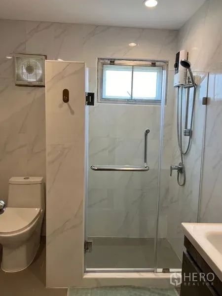 Detached House for sale in Mueang Pathum Thani, Pathum Thani - Modern bathroom with glass shower enclosure, handheld shower and toilet.