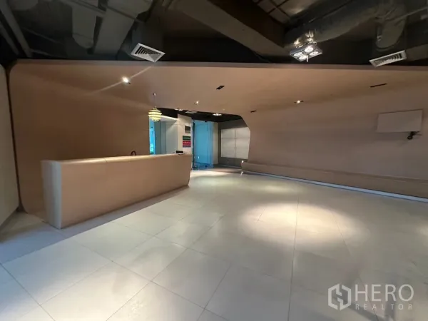Office Space for rent in Khlong Toei, Bangkok - Modern reception lobby with a curved front desk, tiled floors and ceiling spotlights in a Bangkok office.