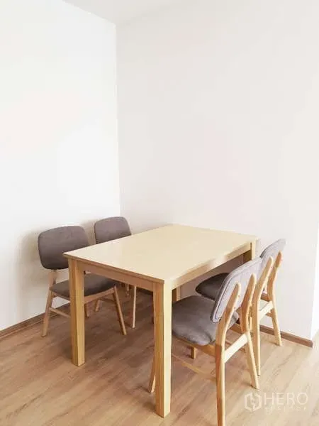 Condominium for sale in Watthana, Bangkok - Cozy dining nook with light wood table and four upholstered chairs.