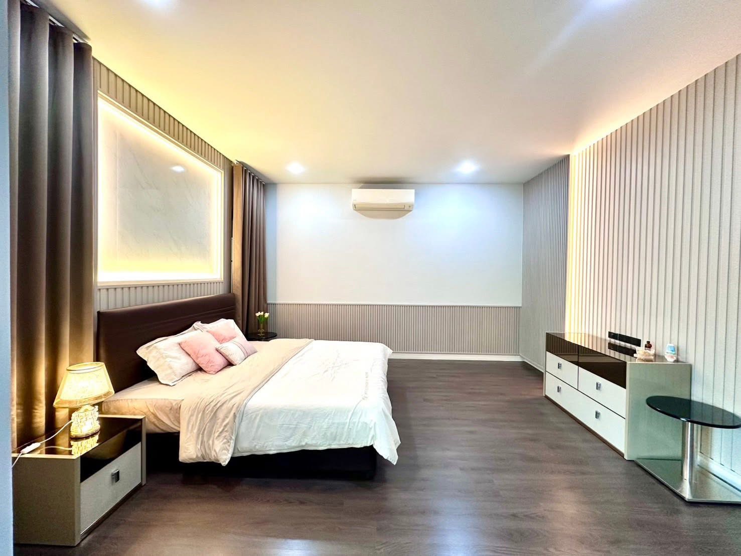 Detached House for rent in Bang Kapi, Bangkok - Large bedroom with bedside tables, air conditioning and wood flooring.