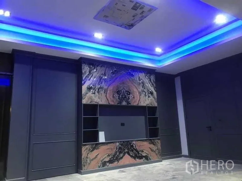 Detached House for sale in Mueang Nonthaburi, Nonthaburi - Media room with blue LED cove lighting and veined stone entertainment wall.