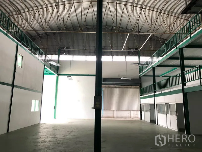 Factory for rent in Lam Luk Ka, Pathum Thani - High‑clearance warehouse hall with arched steel roof and mezzanine walkways.