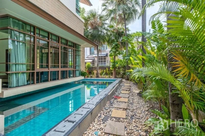 Detached House for rent in Watthana, Bangkok - Private lap pool alongside the house with tropical garden and stone walkway.