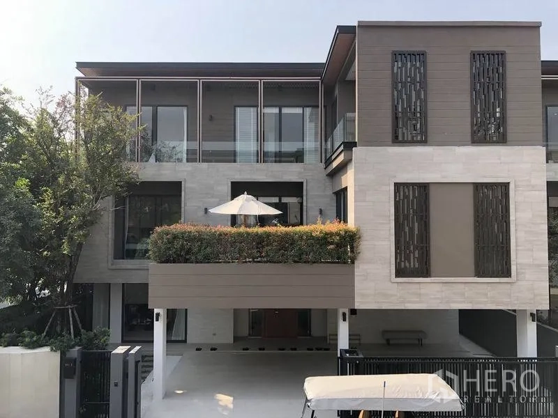 Detached House for sale in Bang Kapi, Bangkok - Modern three-storey detached house facade with balconies, patterned screens and a terrace garden.
