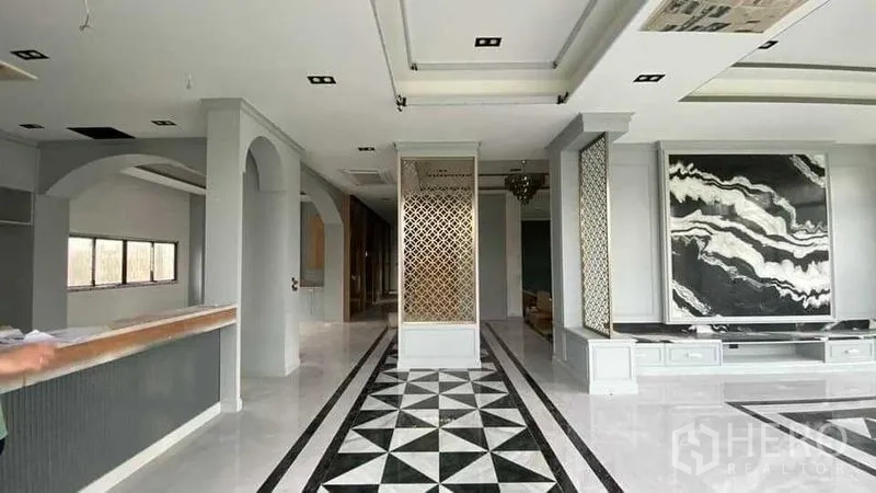 Detached House for sale in Mueang Nonthaburi, Nonthaburi - Open‑plan living area with arches, lattice dividers and patterned walkway flooring.
