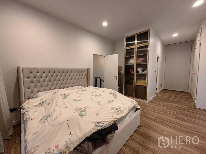 Detached House for rent in Bang Kapi, Bangkok - Master bedroom with upholstered headboard, wardrobes and wood flooring