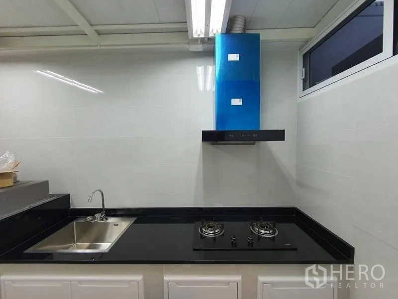 Detached House for rent - Separate Thai kitchen with gas hob, range hood, and sink.